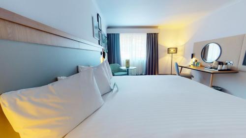 a large white bed in a hotel room at Holiday Inn Cambridge by IHG in Cambridge