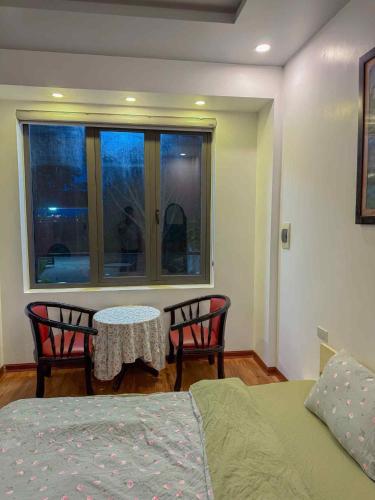 a bedroom with a bed and a table and chairs at Lúa homestay in Hue
