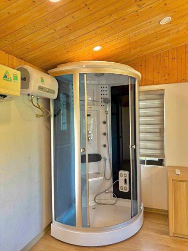 a shower in a room with a wooden ceiling at Lúa homestay in Hue