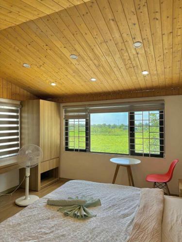 a bedroom with a bed and a table and a window at Lúa homestay in Hue