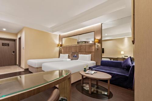 Habitación de hotel con 2 camas y sofá azul en Crystal Orange Hotel Beijing Headquarters Base Branch, en Beijing