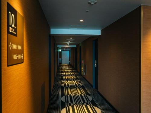 a row of benches in a hallway in a building at Graces Hotels in Inzai