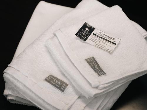 a pile of white towels with labels on them at Graces Hotels in Inzai