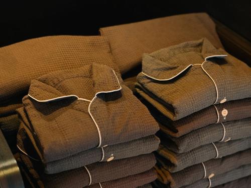 a stack of folded brown towels on a table at Graces Hotels in Inzai