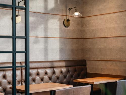 a booth in a restaurant with two tables and benches at Graces Hotels in Inzai