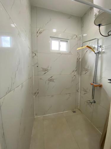 a bathroom with a shower with a glass door at Casa Kappa alibutsweg 15 in Paramaribo