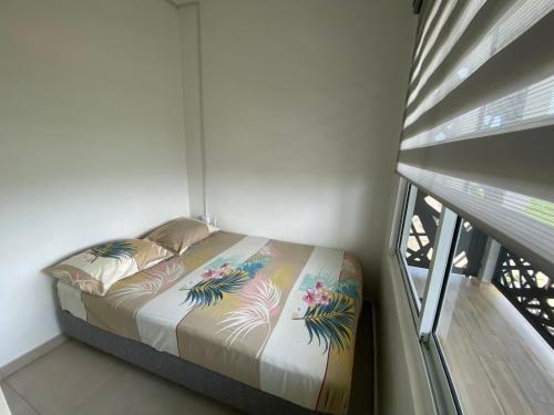 a bed in a room with a window at Casa Kappa alibutsweg 15 in Paramaribo