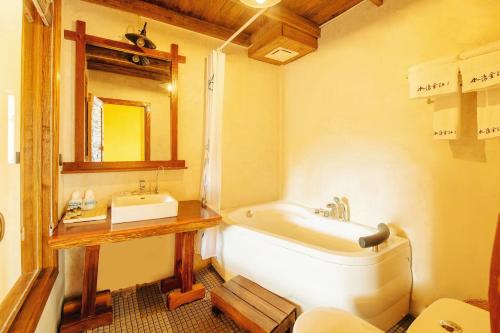 a bathroom with a white tub and a sink at Dayong Antique Feature Resort in Zhangjiajie