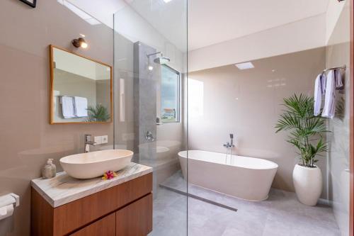 a bathroom with a tub and a sink and a tub and a mirror at Villa Uma Tegal Cemagi in Cemagi