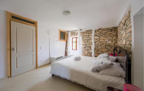 a bedroom with a large bed with a stone wall at 1 Bedroom Awesome Home In Bale in Krmed
