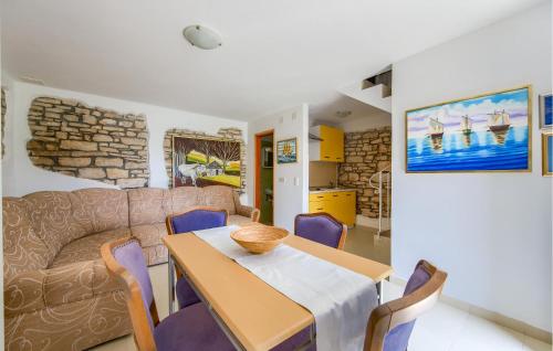 a dining room with a table and a couch at 1 Bedroom Awesome Home In Bale in Krmed