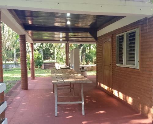 a picnic table sitting on a patio under awning at Casa de Campo En obligado ITAPUA in Obligado
