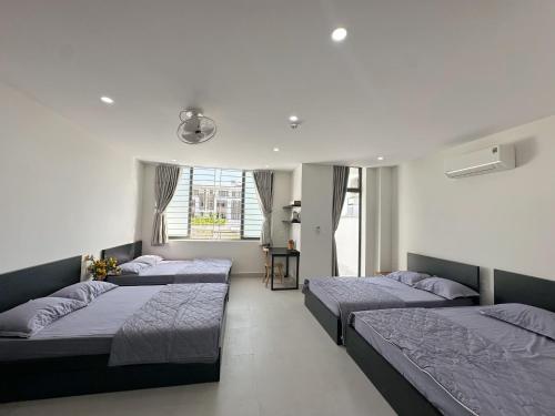 a bedroom with three beds and a window at Khách sạn Na Na Thiên Trà in Quận Ðăng (2)