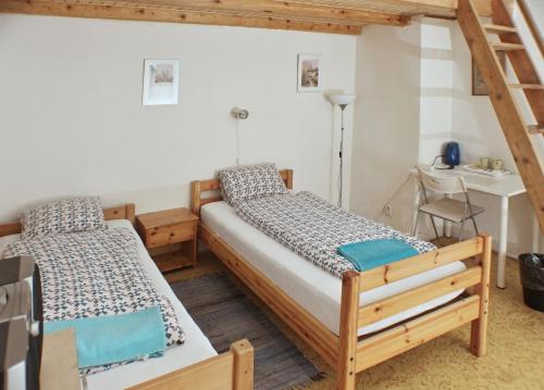 two beds in a room with a desk and a chair at Prague-1 Hostel in Prague
