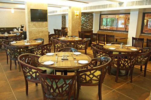 a dining room with wooden tables and chairs at Comfort Inn President Near Ahmedabad Junction Station in Ahmedabad
