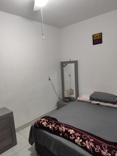 a white room with a bed and a mirror at Departamento en Tonalá in Guadalajara