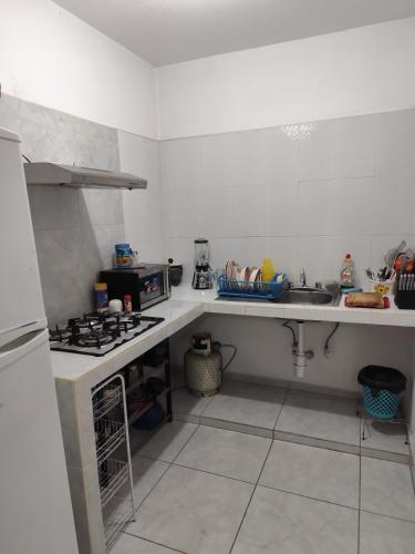a small kitchen with a stove and a sink at Departamento en Tonalá in Guadalajara