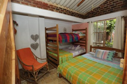 a bedroom with a bunk bed and a chair at Finca Sancami in Guamal