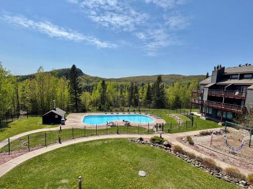 a swimming pool in a yard next to a building at Lutsen Mtn Ski in Ski out Pool Hot Tub Fire Pit in Lutsen