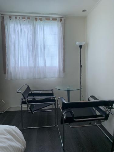 a room with two chairs and a table and a window at 광안해변家 #Gwangan Beach House in Busan