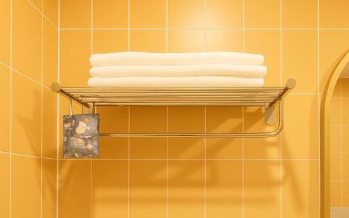 a stack of towels on a towel rack in a bathroom at Gangneung Harubam in Gangneung