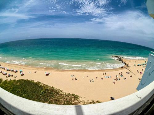 a group of people on a beach near the ocean at Condado Beachfront- Perfect for Families! in San Juan