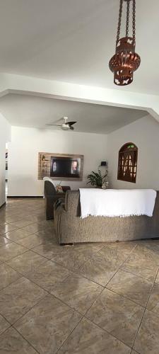 a living room with a bed and a couch at CasaPraiaSol1 in Rio das Ostras