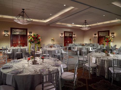 a banquet hall with white tables and chairs and flowers at Austin Southpark Hotel in Austin
