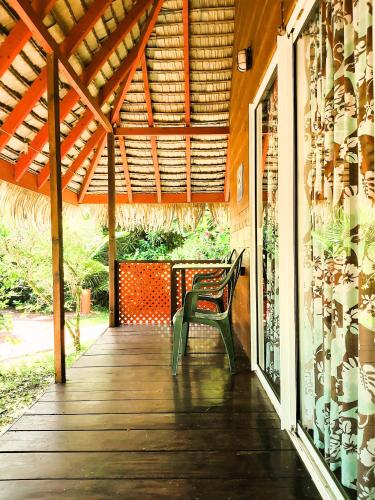 a wooden porch with a bench on a house at HUAHINE - Bungalow Saumon des Dieux in Fare