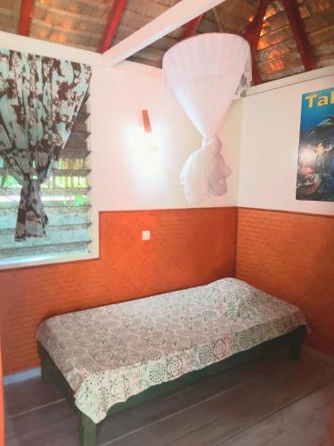 a small bed in a room with a window at HUAHINE - Bungalow Perroquet in Fare