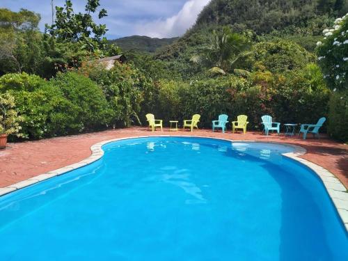 a swimming pool with chairs and tables in a resort at HUAHINE - Bungalow Manta Family in Fare