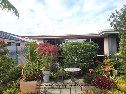 a garden in front of a house with plants at Marina Views in Banksia Beach