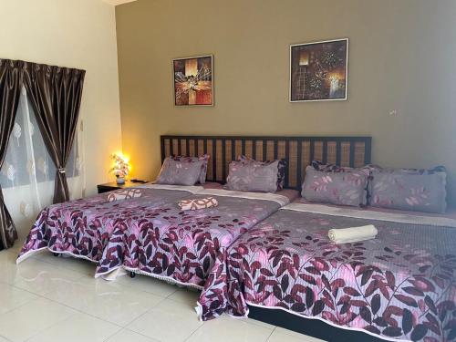 a bedroom with a large bed with a purple comforter at Kak Mar Studio @ Gold Coast Morib Resort in Banting