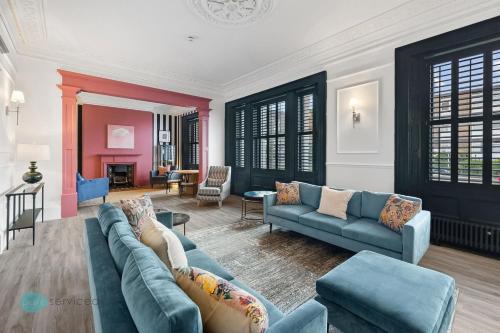 a living room with two blue couches and a living room with a fireplace at Huge spacious 8 bed luxury villa in Plymouth