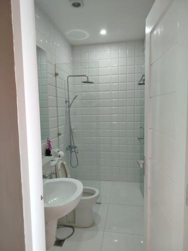 a bathroom with a toilet and a sink at Chequers Suites Subic Bay in Olongapo