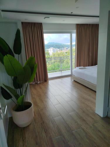 a bedroom with a bed and a potted plant at Chequers Suites Subic Bay in Olongapo