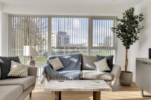 a living room with a couch and a large window at The Pavilion by Pureserviced in Plymouth