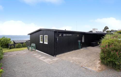 a black building with a bench in front of it at 3 Bedroom Nice Home In Faaborg in Fåborg