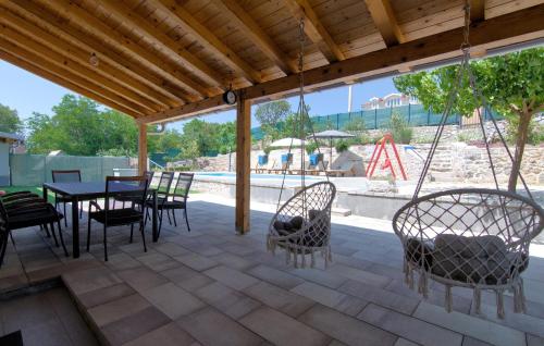 a patio with chairs and a table with a swing at Cozy Home In Imotski With Wifi in Imotski