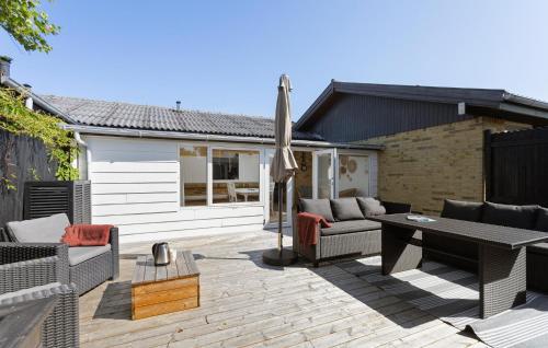 a patio with a table and chairs and an umbrella at 1 Bedroom Awesome Home In Skagen in Skagen