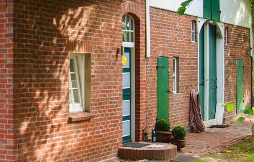 a red brick building with green doors and windows at Beautiful Apartment In Wingst in Wingst