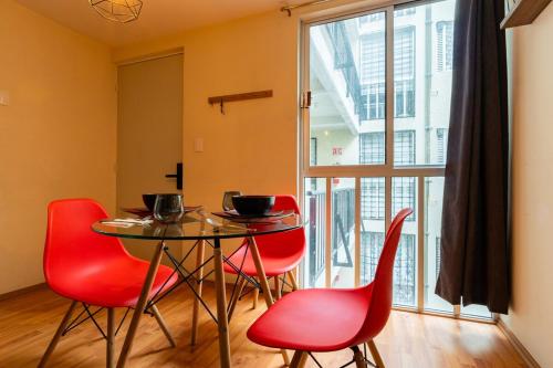 a dining room with red chairs and a table at 10 minutes away from Zocalo in Mexico City
