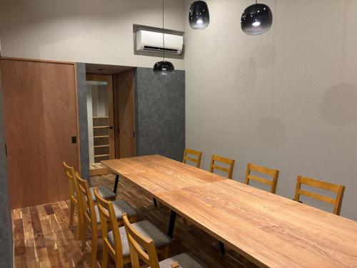 a dining room with a wooden table and chairs at SEN.RETREAT TAKIJIRI in Tanabe