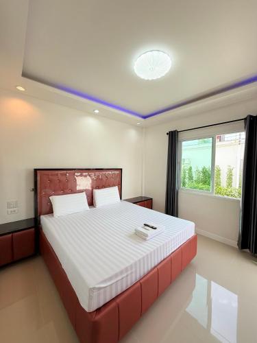 a bedroom with a large bed and a window at โรงแรม พรีโม รีสอร์ท in Ban Bang Phang
