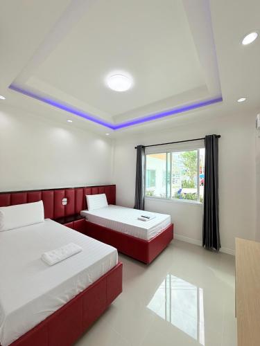 a room with two beds and a window at โรงแรม พรีโม รีสอร์ท in Ban Bang Phang