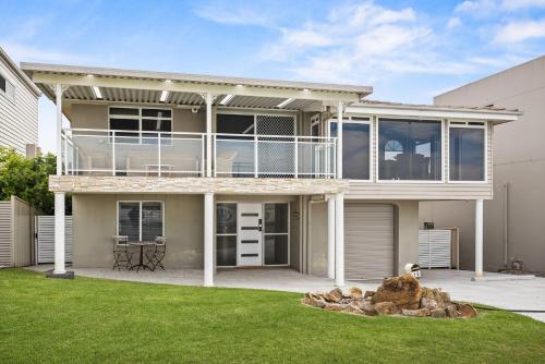 Lake IllawarraにあるSurfside Solaceのバルコニーと庭付きの大きな家