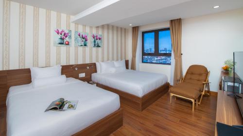 a hotel room with two beds and a television at Rest Hotel & Apartment in Da Nang