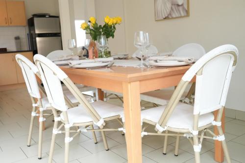 a dining room table with white chairs around it at The Clan Terrigal in Terrigal