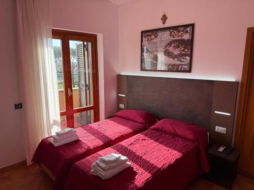 a bedroom with two beds with red sheets and a window at Villa Due Leoni - Casa Per Ferie in Rome