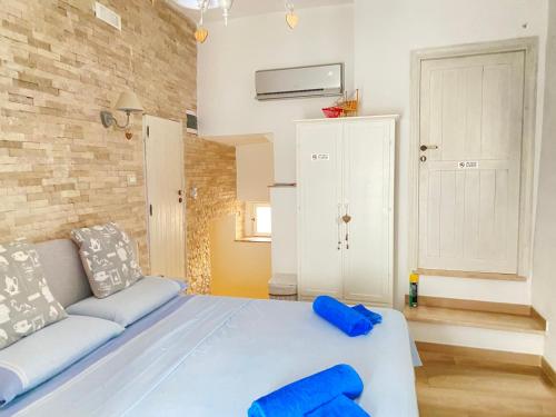 Un dormitorio con una cama azul y un sofá. en Cozy Sea View Flat with Private 83 sq Rooftop, Balcony, and BBQ in the Old Town, en Vieste